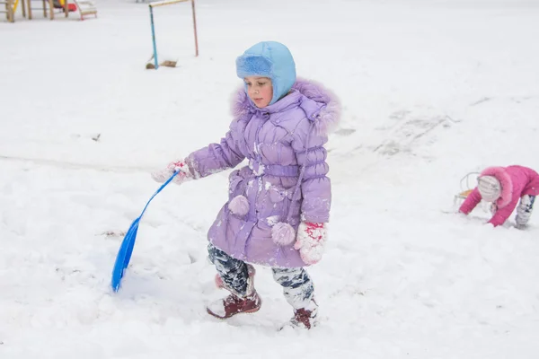 Girl wearily climbs icy hill — Stock Photo, Image