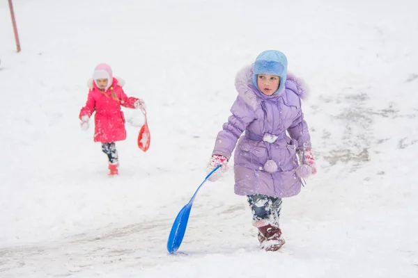 Two girls climb up the icy hill — Stock Photo, Image