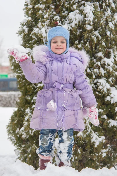 Fille debout sur un banc de neige neige avec boule de neige à la main — Photo