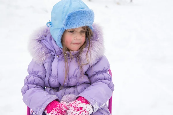 Tired girl sitting on a sled — Stock Photo, Image