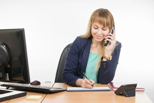 Business woman talking on the phone records in a notebook date business meeting — ストック写真