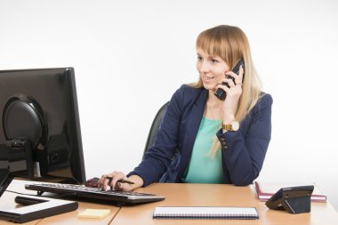 Business woman working in the computer and talking on the phone