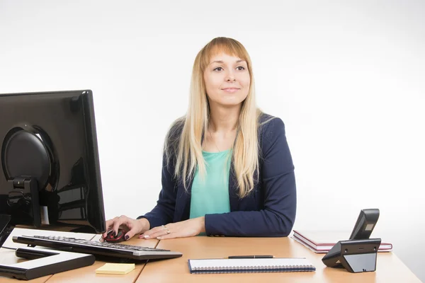 Beautiful girl secretary working at a computer looked at visitor — Stockfoto