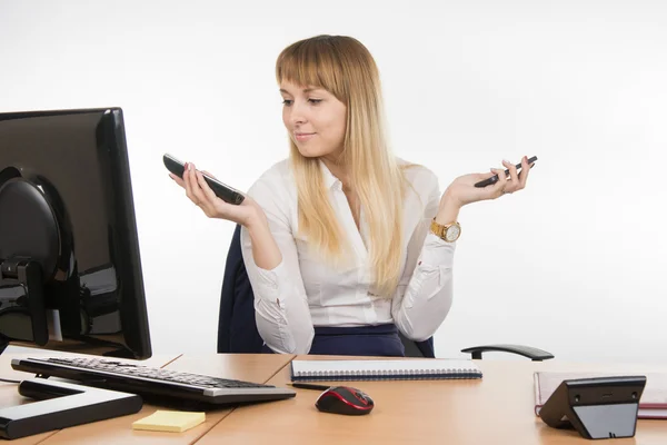 Sekreterare håller två telefon ringde och tittat på arbetet — Stockfoto