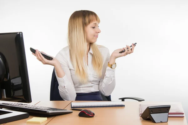 Sekreterare håller två telefon ringde och tittade på mobil — Stockfoto
