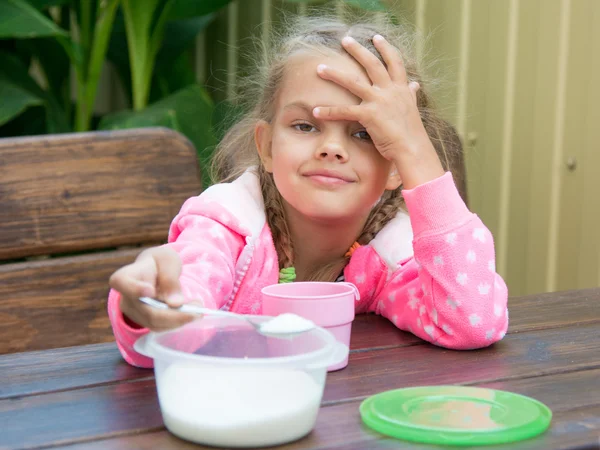 Šestiletá dívka nalévá cukr lžička malá snídaně na terase — Stock fotografie