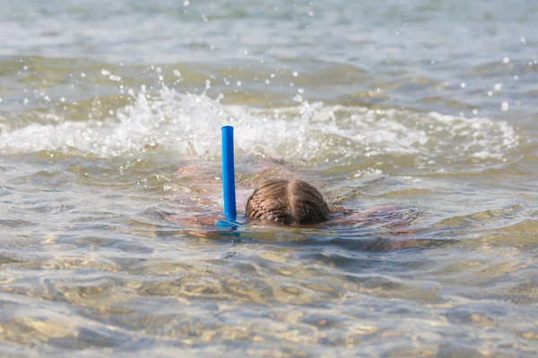 Ragazza galleggia sull'acqua con maschera e boccaglio — Foto Stock