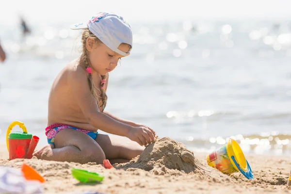 砂で遊ぶビーチ海辺の少女 — ストック写真