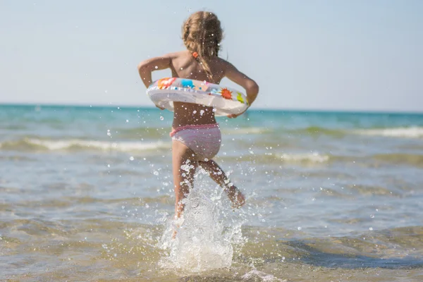 Chica corre a bañarse en el mar, centrarse en un chorro de agua — Foto de Stock