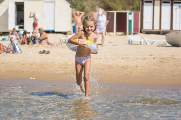 Счастливая девочка бежит купаться в море — стоковое фото