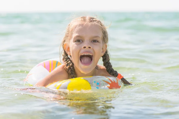 Sex år gammal flicka och bada i havet med munnen öppen i glädje — Stockfoto