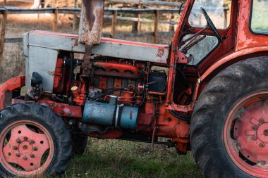 Bulgaristan 'ın kırsal kesiminde güneşli bir sonbahar gününde, eski gümüş boyalı dizel benzin tankı kırmızı, eski Rus traktör motorunda görünür pas ve yağ damlaları görülüyor.