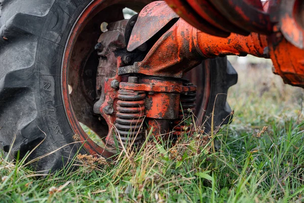 Närbild av stötdämpande sprint på traktor främre däck sällsynta unika röda rostiga ryska fordon jordbruk höst utomhus — Stockfoto