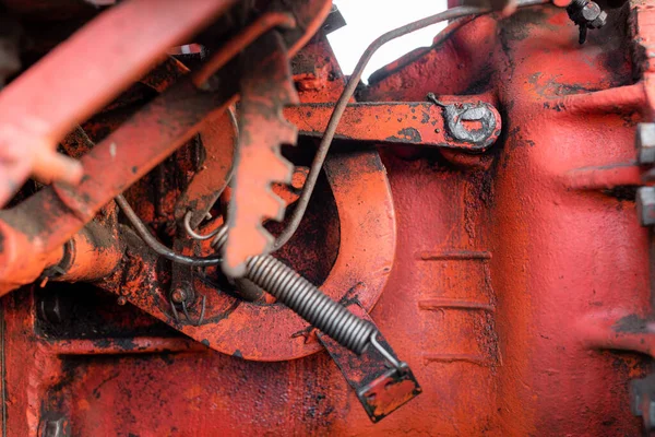 Primo piano del meccanismo idraulico a molla e cablaggio su vecchio trattore russo arrugginito con macchine per la raccolta dell'olio grasso autunno — Foto Stock
