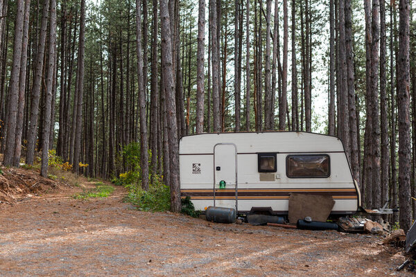 Заброшенный дом на колёсах трейлера в лесу симметрия контрастирует с резкими деталями и яркими цветами
