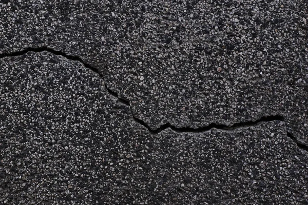 Dark texture of old broken asphalt road or wall big abrasions cracks on the surface pebbles cement in Sofia, Bulgaria, Eastern Europe — Stock Photo, Image