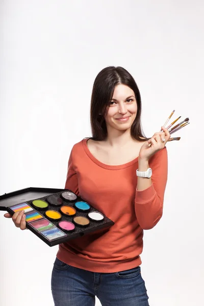 Young female painter with a palette of paints and brushes — Stock Photo, Image