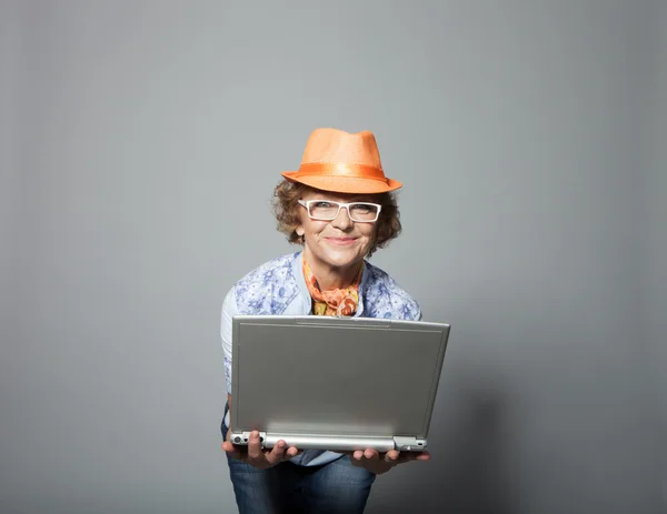 Bir dizüstü bilgisayar ile şık yaşlı kadın — Stok fotoğraf
