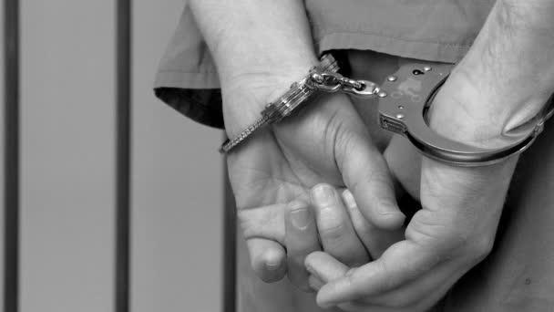 Охранник снимает наручники с заключенных — стоковое видео