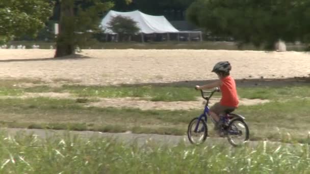 Gyerekek bicikliznek a parkban. — Stock videók