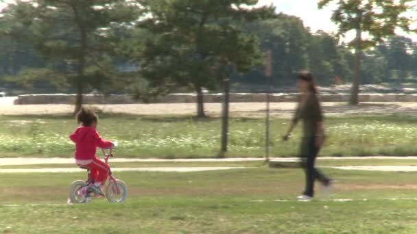 Meisje rijden fiets in het park — Stockvideo