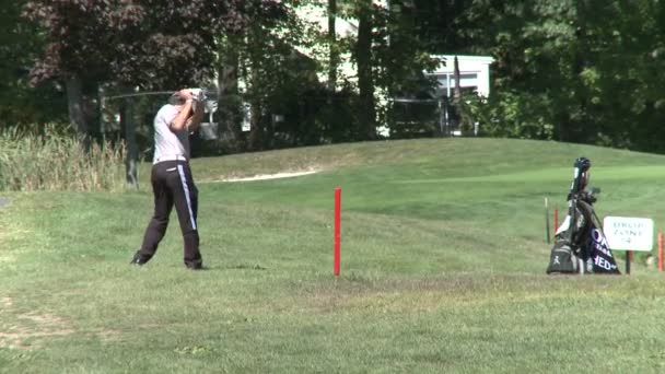 Golfer hitting over path — Stock Video