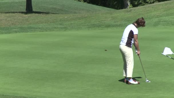 Feminino golfista putts bola e está animado — Vídeo de Stock