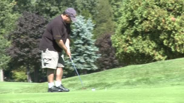 Golfer zich voorbereidt op de bal putt — Stockvideo