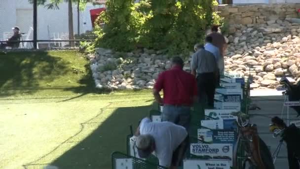 Golfistas practicando en el campo de prácticas — Vídeo de stock