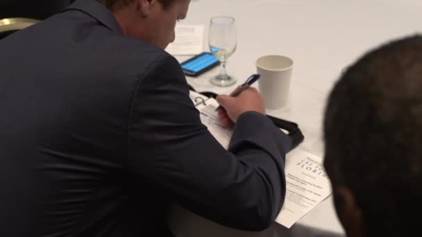 Um profissional usando uma caneta um papel para tomar notas — Vídeo de Stock