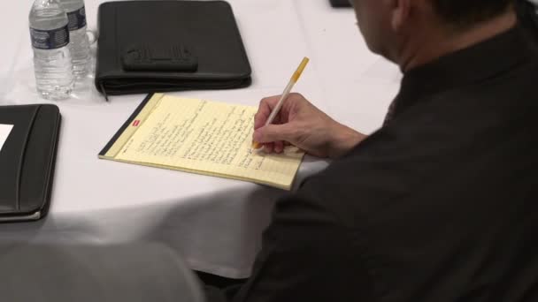 Профессионал использует ручку бумагу, чтобы делать заметки — стоковое видео