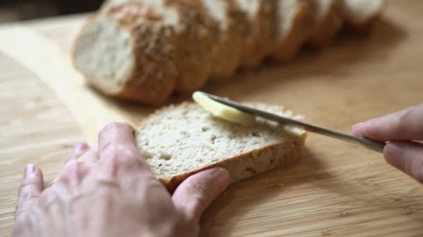 Person som smörar skiva bröd — Stockvideo