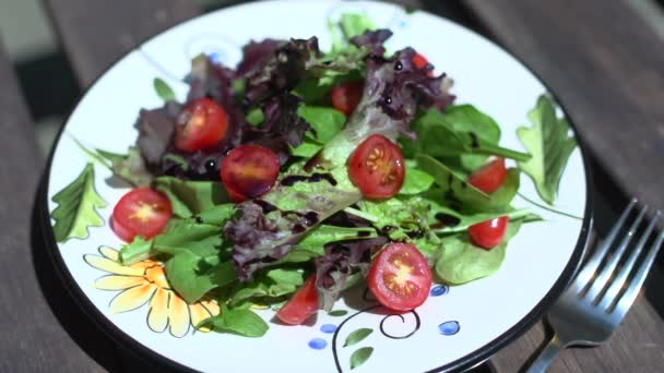 Una ensalada fresca en una mesa iluminada por el sol — Vídeos de Stock