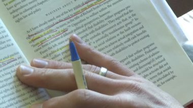 Bir kitapta (2 / 2 okuyor çizgi takip etmek bir kalem kullanan kişi)