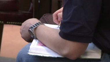 Genç bir adam bir kitap notları kütüphanede yapma