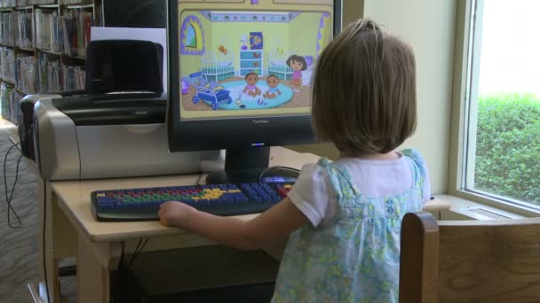 Niño pequeño usando una computadora en la biblioteca (1 de 3 ) — Vídeo de stock