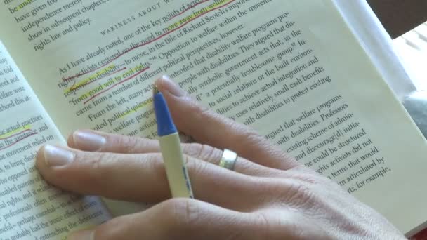 Persona che usa una penna per seguire la linea che sta leggendo in un libro (2 di 2 ) — Video Stock