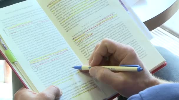 Persona che usa una penna per seguire la linea che sta leggendo in un libro (1 di 2 ) — Video Stock
