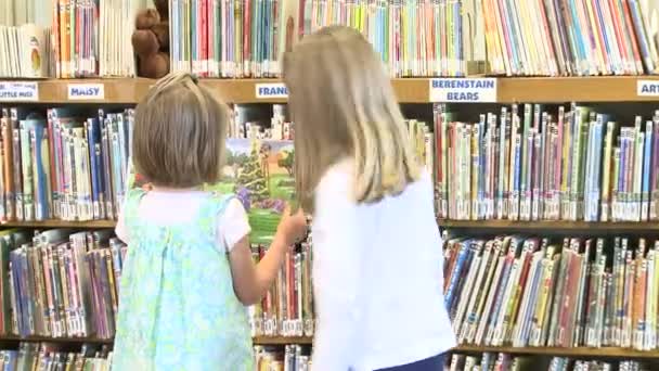 Una niña buscando un libro de sus amigos — Vídeo de stock