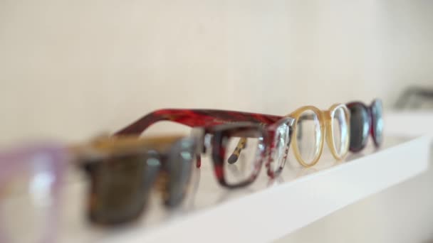 Eyeglasses on the shelf in shop — Stock Video