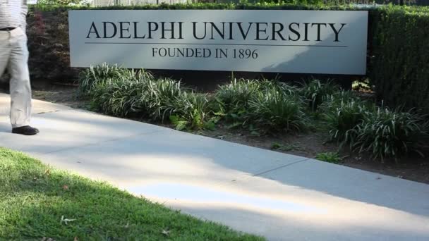 Paseo peatonal por Adelphi University sign (2 de 2 ) — Vídeo de stock