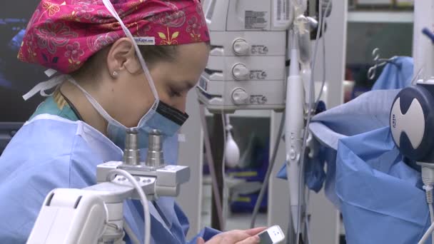 Anestesiologista usa telefone celular — Vídeo de Stock