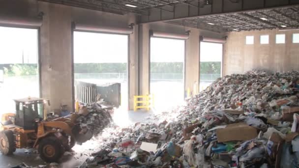 Un cargador frontal mueve la basura en un centro de reciclaje (7 de 9 ) — Vídeo de stock