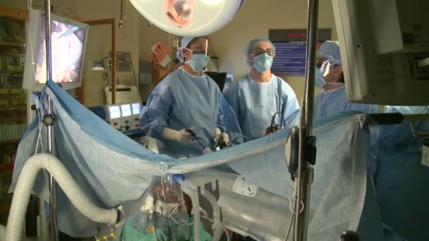 Хирурги, выполняющие роботизированную операцию — стоковое видео