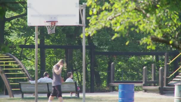 Remaja anak laki-laki menembak hoops di taman — Stok Video