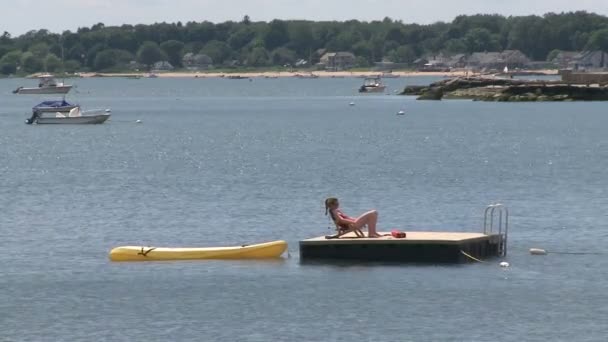 Mujer tomando el sol en una balsa con un bote de goma atado a ella (1 de 2 ) — Vídeo de stock