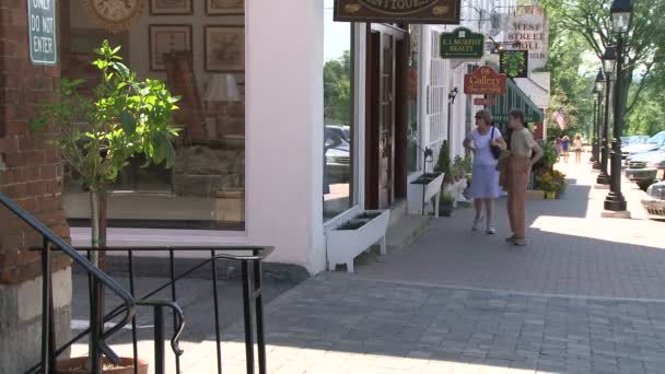 Две женщины идут перед магазином — стоковое видео