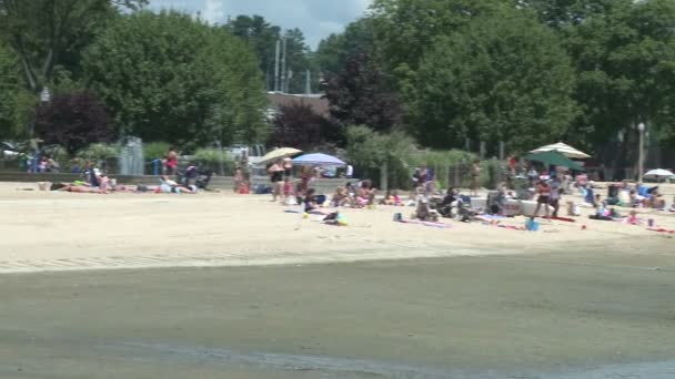 Personer på stranden med paraplyer. — Stockvideo