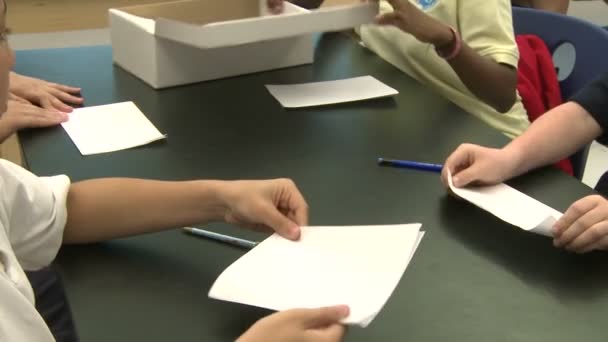 Cuatro estudiantes de primaria que trabajan en una mesa (2 de 3 ) — Vídeo de stock