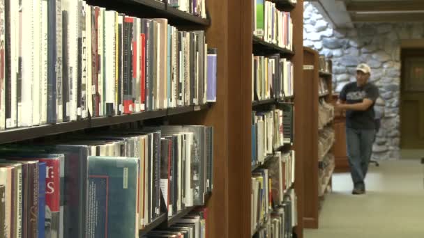 图书馆的人搜寻书架 (2 的4) — 图库视频影像